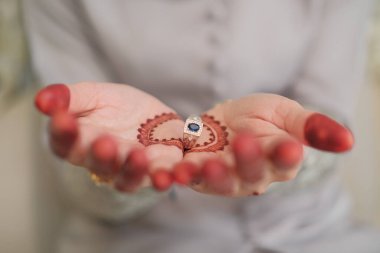 Malezyalı gelin damadın parmağına yüzük takıyor. Gelin, damadın sol parmağına alyans takar, Müslüman düğünü, düğün posterleri, elini kapat..