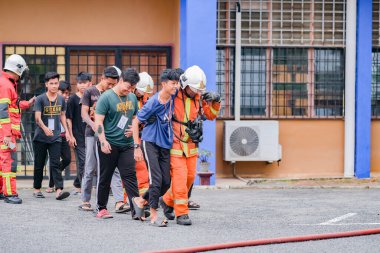 Muadzam Şah, Malezya - 10 Ağustos 2023: İtfaiyeciler 2023 Ajanslar Arası Felaket Eğitim Programı 'nda bir yangın tatbikatında yaralı bir genci kurtardılar