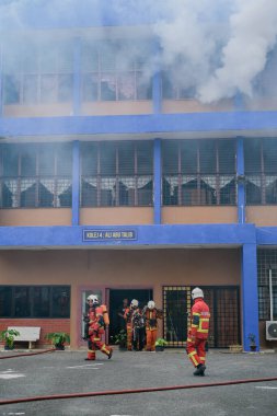 Muadzam Şah, Malezya - 10 Ağustos 2023: İtfaiyeciler 2023 Ajanslar Arası Felaket Eğitim Programı 'nda bir yangın tatbikatında yaralı bir genci kurtardılar