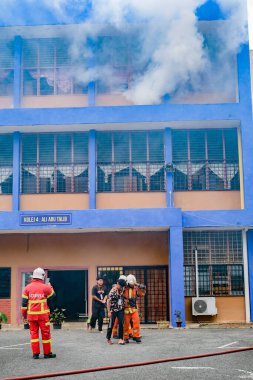Muadzam Şah, Malezya - 10 Ağustos 2023: İtfaiyeciler 2023 Ajanslar Arası Felaket Eğitim Programı 'nda bir yangın tatbikatında yaralı bir genci kurtardılar