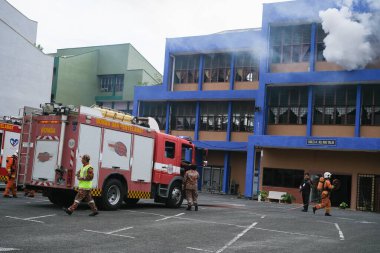 Muadzam Şah, Malezya - 10 Ağustos 2023: İtfaiyeci bir ateşe suyla saldırıyor. İtfaiyeci ekibi, 2023 Ajanslar Arası Felaket Eğitim Programı 'nda yangın tatbikatı sırasında çalışıyor.