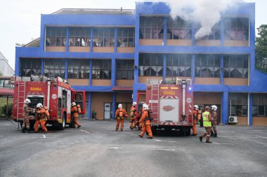 Muadzam Şah, Malezya - 10 Ağustos 2023: İtfaiyeci bir ateşe suyla saldırıyor. İtfaiyeci ekibi, 2023 Ajanslar Arası Felaket Eğitim Programı 'nda yangın tatbikatı sırasında çalışıyor.