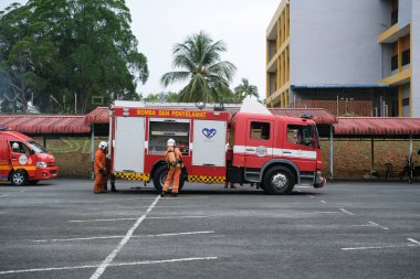 Muadzam Şah, Malezya - 10 Ağustos 2023: İtfaiyeci bir ateşe suyla saldırıyor. İtfaiyeci ekibi, 2023 Ajanslar Arası Felaket Eğitim Programı 'nda yangın tatbikatı sırasında çalışıyor.