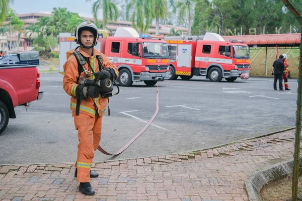 Muadzam Şah, Malezya - 10 Ağustos 2023: İtfaiyeci bir ateşe suyla saldırıyor. İtfaiyeci ekibi, 2023 Ajanslar Arası Felaket Eğitim Programı 'nda yangın tatbikatı sırasında çalışıyor.