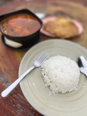 Omlet ve beyaz pirinç baharatlı tomyam ile sıcak ve ekşi çorba yerler.