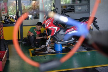 Segamat, Malezya - 3. Şube, 2024: Segamat 'ta bir motosikleti tamir eden tamirci.