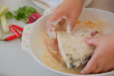 Kadın şefin elleri balık yemi hazırlıyor.