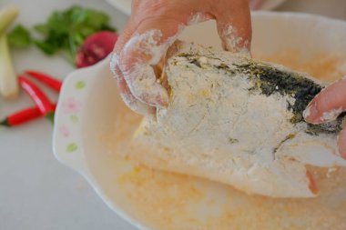 Kadın şefin elleri balık yemi hazırlıyor.