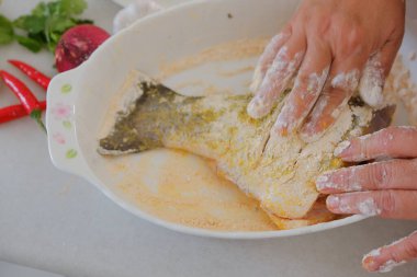 Kadın şefin elleri balık yemi hazırlıyor.