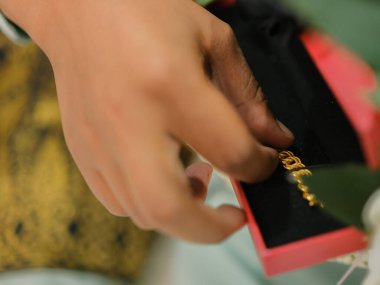 Damat, resmi tören sırasında geline bileziği taktı. Aile ve mutluluk kavramı.