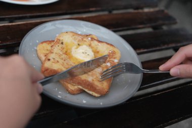 Kahveyle kahvaltı, tost, sahanda yumurta ve ahşap masada reçel.