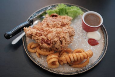 Bir tabak tavuk pirzolası ve yanında patates kızartması.