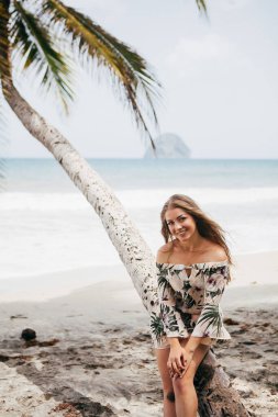 Sahildeki palmiye ağacının yanında güzel bir kız