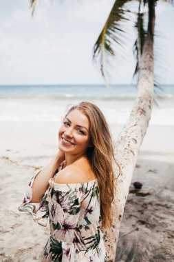Sahildeki palmiye ağacının yanında güzel bir kız