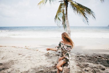 Sahildeki palmiye ağacının yanında güzel bir kız
