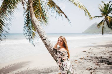 Sahildeki palmiye ağacının yanında güzel bir kız