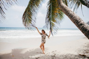 Sahildeki palmiye ağacının yanında güzel bir kız