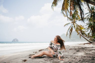 Sahildeki palmiye ağacının yanında güzel bir kız