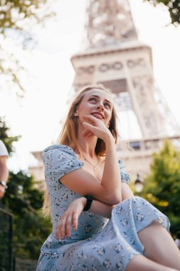 Paris 'teki Eyfel Kulesi' nin yanında mavi elbiseli, güzel ve zarif bir kadın.
