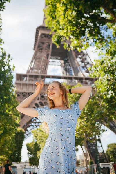 Paris 'teki Eyfel Kulesi' nin yanında mavi elbiseli, güzel ve zarif bir kadın.