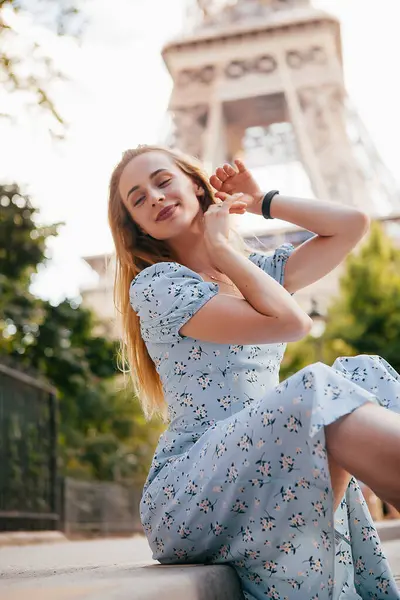 Paris 'teki Eyfel Kulesi' nin yanında mavi elbiseli, güzel ve zarif bir kadın.