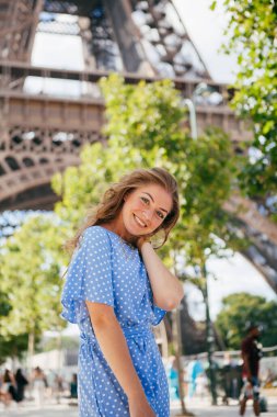 Elbiseli güzel bir kız Eyfel Kulesi 'nin yanında poz veriyor.