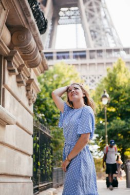 Elbiseli güzel bir kız Eyfel Kulesi 'nin yanında poz veriyor.