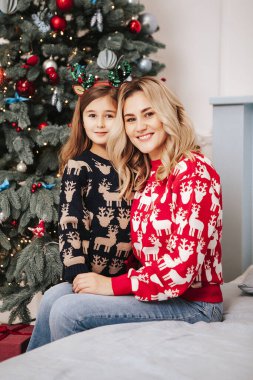 Genç güzel anne kızıyla birlikte Noel ağacının yanında.