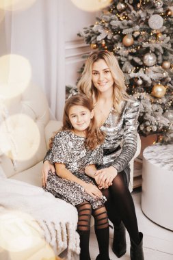 Genç güzel anne kızıyla birlikte Noel ağacının yanında.