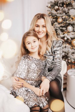Genç güzel anne kızıyla birlikte Noel ağacının yanında.