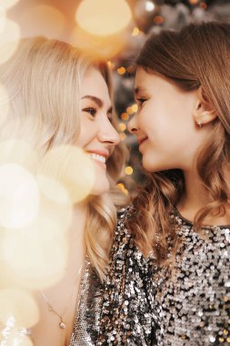 Genç güzel anne kızıyla birlikte Noel ağacının yanında.