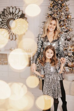 Genç güzel anne kızıyla birlikte Noel ağacının yanında.