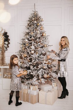 Genç güzel anne kızıyla birlikte Noel ağacının yanında.