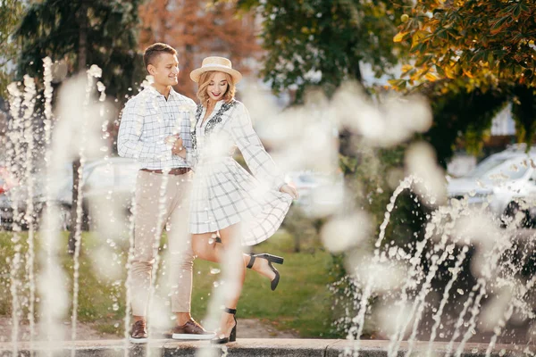 美丽的一对恋人在喷泉边微笑 — 图库照片