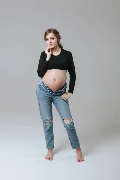 Beyaz Arka Planda Kot Pantolonlu Hamile Bir Kız — Stok fotoğraf
