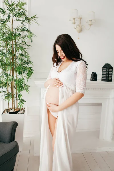 美しいです妊娠中の女の子で白いドレスでインテリア — ストック写真