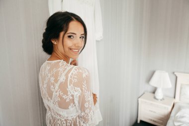 Genç esmer kadın yatak odasında.