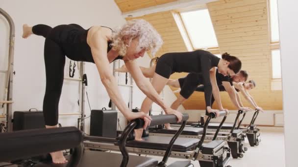 健康的生活方式 小企业的概念 三个运动小组在现代普拉提工作室内部的改造床上进行锻炼 — 图库视频影像