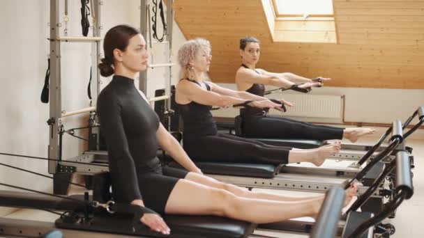 Grupp Vackra Kvinnor Bär Svarta Sportkläder Gör Reformer Stretching Övningar — Stockvideo