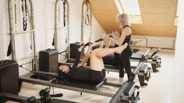 Kvinnor Som Gör Pilates Övningar Liggande Pilates Träningsmaskiner Medan Deras — Stockvideo