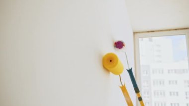 Yakından bir adam duvarda boya silindiri tutuyor. Meçhul bir kadın, patenciyi yüzeyde bir başkasına yönlendiriyor. Tanımlanamayan çift birlikte yeni bir daire boyuyor. Bir Evi Boyayan Ressam.