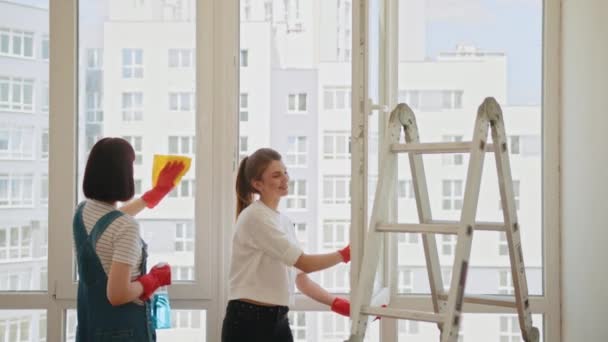 Дві Позитивні Жінки Прибирають Кімнату Разом Жіночі Рукавички Очищають Вікно — стокове відео