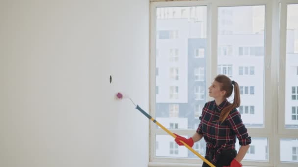 Donna Dipinge Parete Colore Bianco Mentre Riparazione Appartamento Appena Acquistato — Video Stock