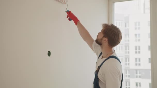 페인트 롤러와 페인트를 사용하여 그림을 그리는 장갑을 페인트 롤러를 남자를 — 비디오