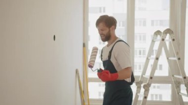 Ev inşaatı sırasında paten fırçasını gitar olarak kullanarak tamirci. Evi yenilerken şarkı söyleyen adam. Dairenin dekorasyonu ve tadilatı, tadilat ve tadilat sırasında. Onarım ve dekorasyon