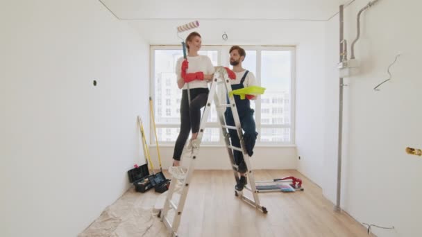 Happy Young Couple Showing Tools Repair While Standing Ladder Smiling — Video