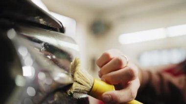 Close up of hands of auto service male worker in black protective gloves cleaning car hood and headlights with foam and soft brush. Car Wash and detailing. Auto service male worker.