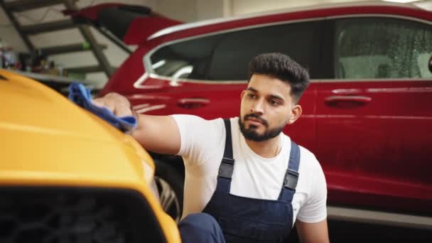 가죽이 벗겨진 자동차 보호용 작업복을 최신식 승용차를 마이크로 천으로 청소하는 — 비디오
