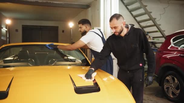 자동차 차장들은 보호용 작업복을 남자들을 척하고 현대식 노란색 승용차에 마이크로 — 비디오