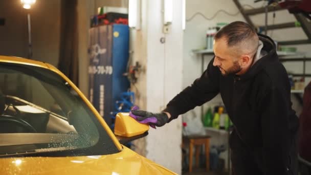 Young Bearded Male Car Service Worker Black Rubber Glove Holding — Stockvideo